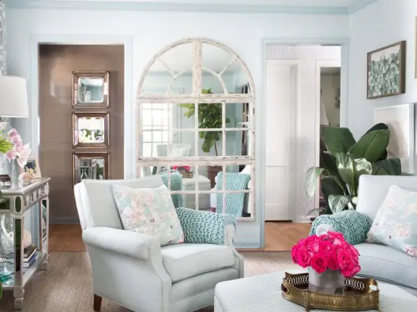 Charming mirror wall ideas: a large arched window mirror and stacked square mirrors create depth and light in this elegant living room.