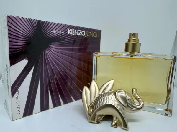 Złoty słoń strzeże flakonu Kenzo Jungle 100ml z fioletowym, liściastym wzorem na opakowaniu.