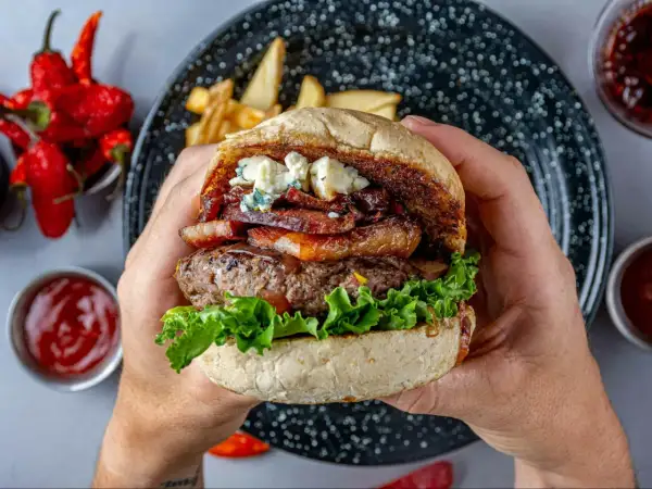 Soczysty burger z udźca wołowego, boczkiem, serem pleśniowym i chrupiącą sałatą. Idealny na letnie grillowanie.