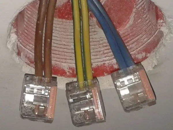 Instalacja elektryczna: brązowe przewody, żółto-zielony i niebieski, połączone w kostkach. Czy faza to plus czy minus?