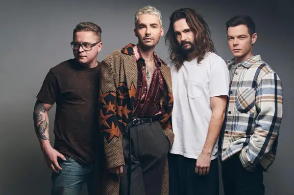 Tokio Hotel Polska: czterech mężczyzn w stylowych strojach pozuje do zdjęcia. Jeden z nich ma tatuaż na ramieniu.