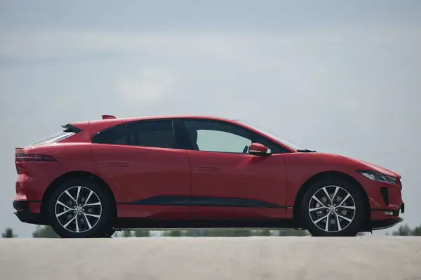 Czerwony Jaguar I-PACE na tle błękitnego nieba. Elegancki, elektryczny SUV gotowy do dynamicznej jazdy.