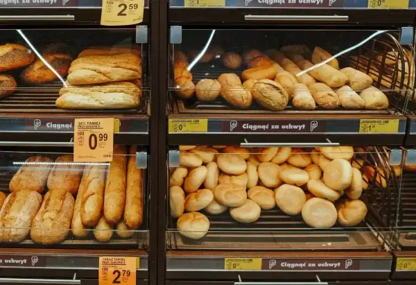 Na półkach sklepowych widać świeże pieczywo: bułki z ziarnami, bagietki i chlebki. Idealne na śniadanie, choć warto sprawdzić bułka z ziarnami kcal.