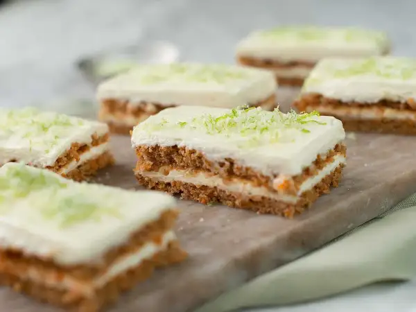 Små bitar av saftig morotskaka med krämig frosting och rivet limeskal. Perfekt för ett enkelt morotskaka recept.