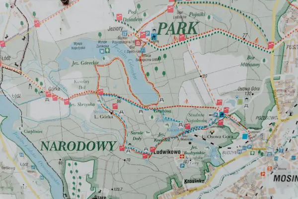 Mapa szlaków turystycznych w Wielkopolskim Parku Narodowym. Widoczne jeziora, lasy, punkty widokowe i zabytki.