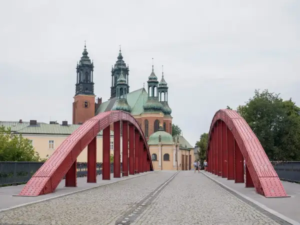 Czerwony most na Ostrowie Tumskim w Poznaniu, idealny na spacer i odkrywanie poznańskich atrakcji dla dorosłych. W tle katedra.