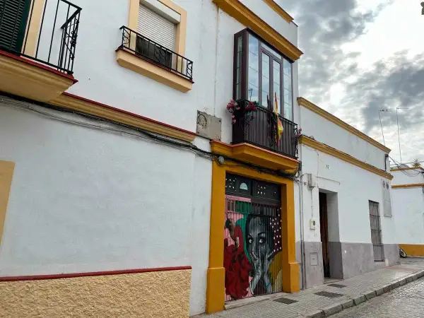Fachada de la casa Lola Flores en Jerez, con un mural vibrante en la puerta y balcones adornados.