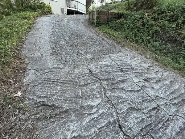 Stromy podjazd z popękanego betonu, porośnięty trawą. Zastanawiasz się, czym wyłożyć stromy podjazd, by był bezpieczniejszy i estetyczniejszy?