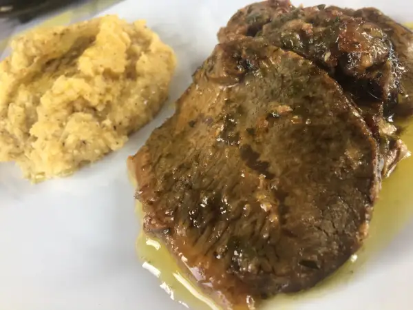 Fette di carne in umido con polenta, un classico della ricetta bresciana.
