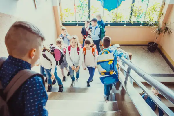 Dzieci z plecakami schodzą po schodach, jakby wracały do domu po lekcjach. Może to dzień, w którym weszła w życie ustawa Kamilka, zapewniająca im bezpieczeństwo.