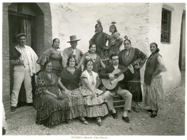 Grupo de gitanos en Granada, con un hombre tocando la guitarra. Captura la esencia del significado del flamenco.