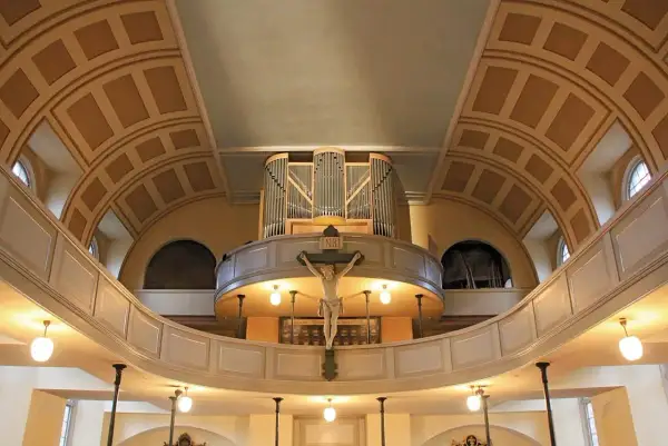 Orgel und Kruzifix im St. Pauli Dom. Die geschwungene Empore und die kunstvolle Deckenkonstruktion schaffen eine feierliche Atmosphäre.