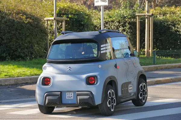 Citroën Ami in prova su strada, vista posteriore. Un veicolo elettrico compatto e originale, ideale per la mobilità urbana.