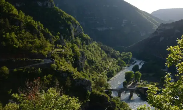 La famille Bournazel profite d'une vue spectaculaire sur une vallée verdoyante, une rivière scintillante et un pont de pierre.