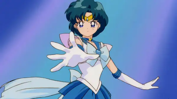 Sailor Mercury wyciąga rękę, gotowa do walki. Jej niebieskie włosy i strój podkreślają jej moc.