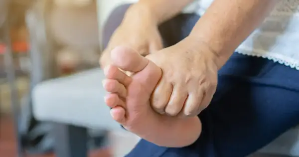 Dłoń masuje stopę, co może być jednym z objawów nadmiaru potasu.