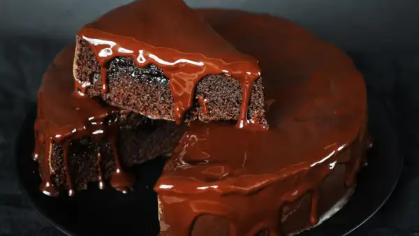 Saftiger Schokokuchen mit glänzender Schokoladenglasur, der wie von Zauberhand im Thermomix entstanden ist.