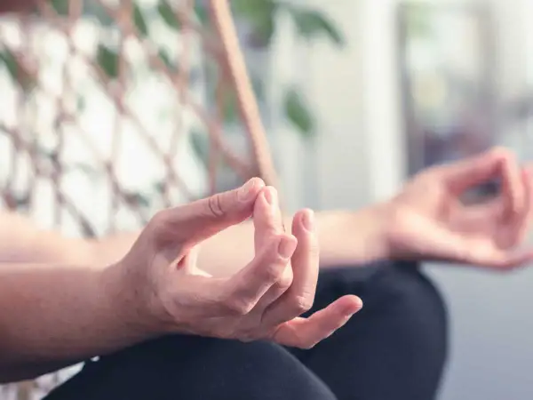 Mains en mudra, pratiquant des exercices de yoga des mains pour la relaxation et la concentration.