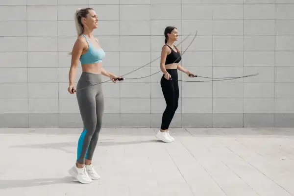 Dwie kobiety ćwiczą z linkami. Idealna skakanka do crossfitu to klucz do efektywnego treningu.