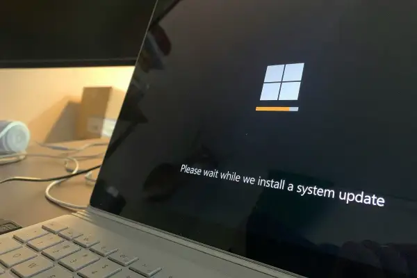 Ekran laptopa z logo Windows i paskiem postępu. System Windows 10 LTSC instaluje aktualizację.