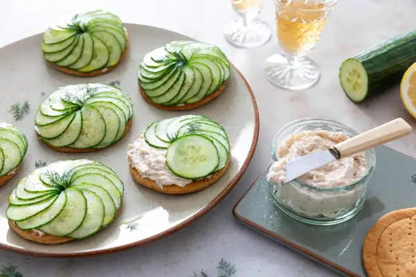 Délicieuses tartelettes salées gastronomiques ornées de fines rondelles de concombre disposées en spirale, garnies d'une touche d'aneth.