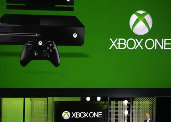 Konsola Xbox One i kontroler na zielonym tle. Premiera Xbox One w 2013 roku.