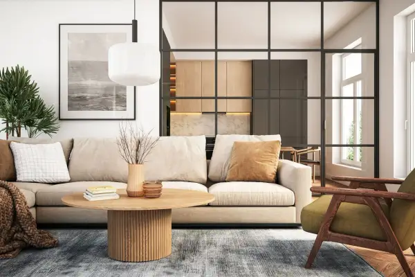 Gemütliche zimmer einrichtung mit beigem Sofa, Holztisch und grüner Sessel. Im Hintergrund offene Küche mit Holzelementen.