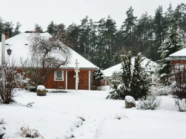 Śnieżne Boże Narodzenie na Kaszubach. Drewniane domki agroturystyki otoczone lasem i pokryte białym puchem.