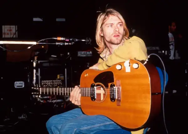 Kurt Cobain z gitarą akustyczną, symbol grunge'u i muzyki, która zdefiniowała pokolenie.