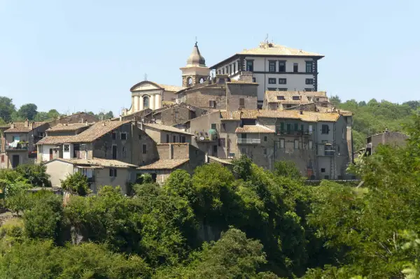 Borgo medievale di Gradoli, affacciato sul lago di Bolsena, con case in pietra e una chiesa con campanile.
