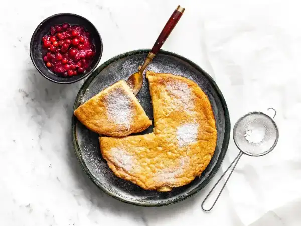 Puszysty omlet z airfryer, posypany cukrem pudrem, podany z żurawiną. Idealny na śniadanie.
