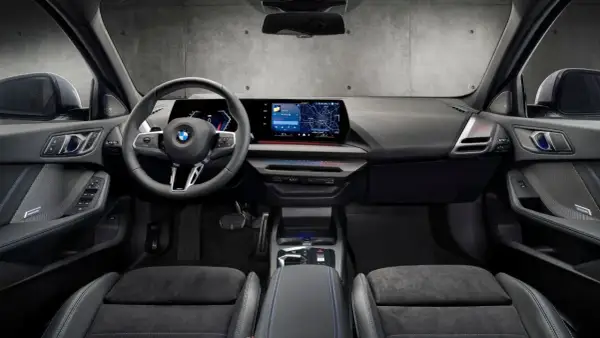 Interiör i en BMW med digital instrumentpanel, stor infotainmentskärm som visar navigation och en ratt med Steptronic-funktion.
