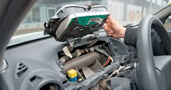 Wymiana żarówek przód w Opel Vivaro. Widok wnętrza zdemontowanego kokpitu, widoczne przewody i elementy deski rozdzielczej.
