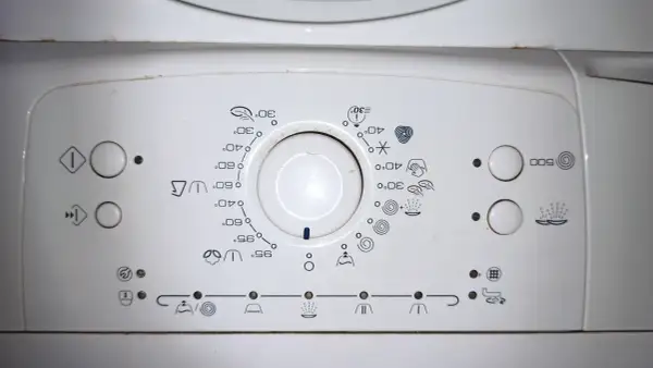 Panel sterowania pralki Whirlpool z ikonami programów i temperatur. Pomoc w obsłudze urządzenia.