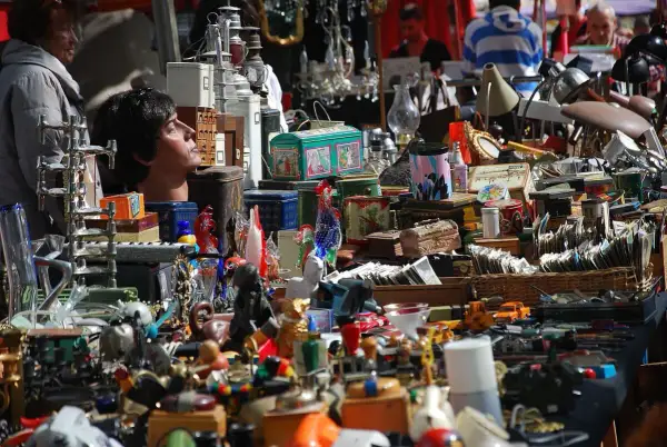 Buntes Treiben auf dem Flohmarkt Kelheim: Ein Kopf einer Schaufensterpuppe blickt neugierig in die Menge, umgeben von allerlei Trödel und Schätzen.