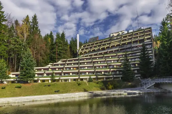 Hotel Granit w Szklarskiej Porębie, tarasowy budynek z widokiem na las i staw. Sprawdź cennik pobytu.