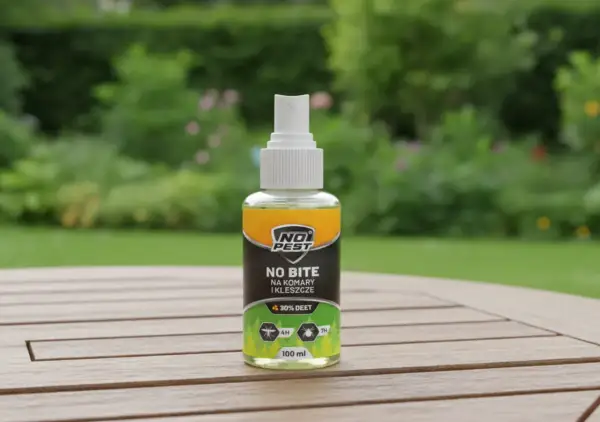 Butelka sprayu "No Bite" z 30% DEET, najmocniejszy środek na komary i kleszcze, na drewnianym stole w ogrodzie.