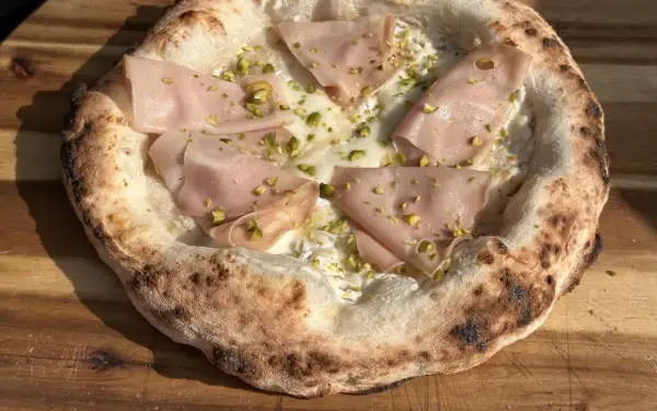 Neapolitanische Pizza Rezept: Köstliche Pizza mit Mortadella, Pistazien und cremiger Käsesauce.