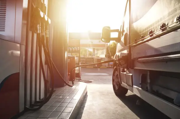 Lastenbilen tankas med diesel i solnedgången. En gammal dieselmotor behöver sin energi.