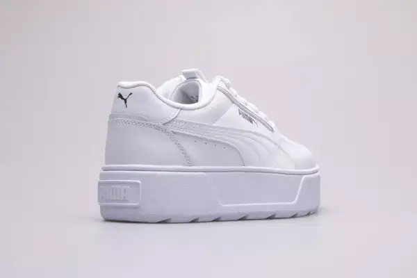 Białe buty na platformie Puma Karmen Rebelle Jr. z czarnym logo.