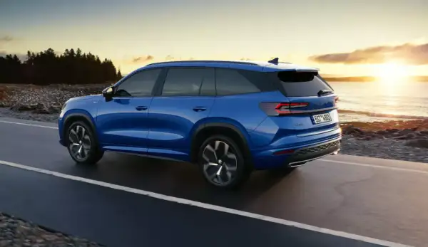 Niebieski Skoda Kodiaq jedzie wzdłuż wybrzeża o zachodzie słońca. Poznaj jego imponujące skoda kodiaq wymiary.