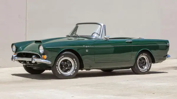 En grön Sunbeam Tiger cabriolet, en klassisk sportbil, står parkerad.