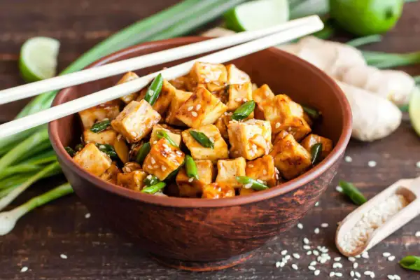 Kawałki tofu w sosie, posypane sezamem i szczypiorkiem, gotowe do podania. Idealna marynata do tofu!