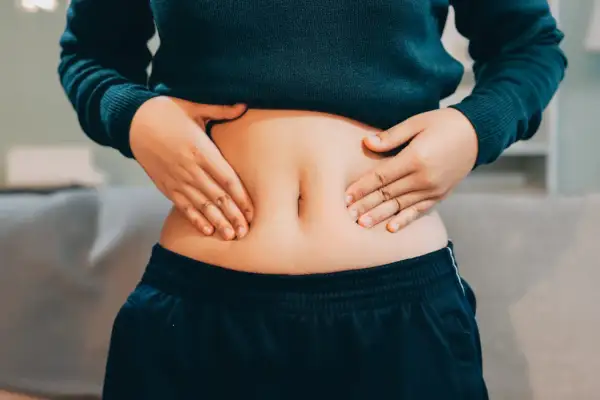 Mani che stringono la pancia, che nonostante sia magra, appare gonfia e dura.