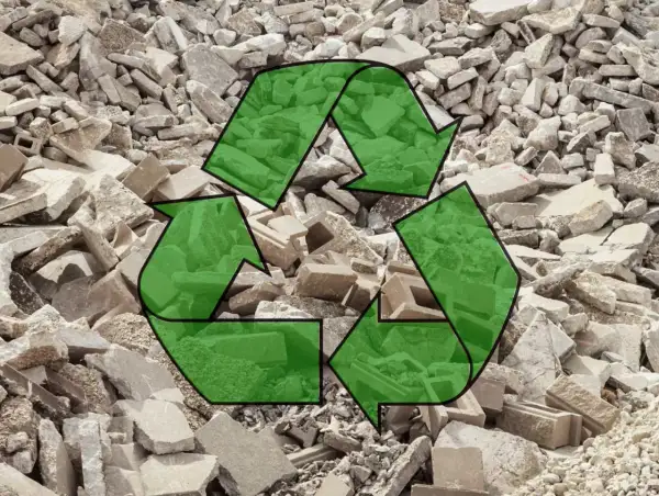 Símbolo de reciclaje verde sobre un montón de escombros de hormigón reciclado.
