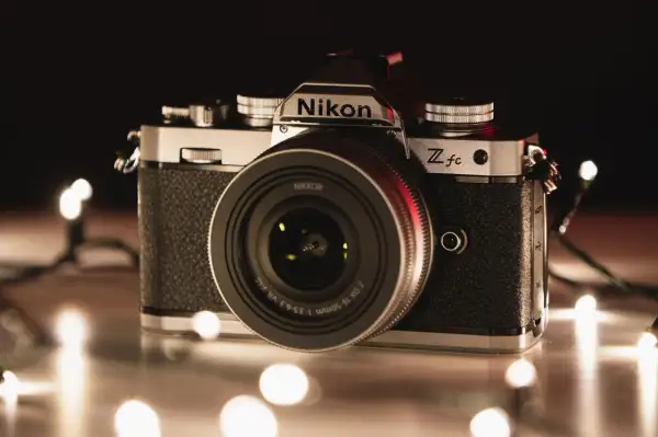 Nikon Z fc, jeden z rodzajów aparatów, otoczony świątecznymi lampkami.