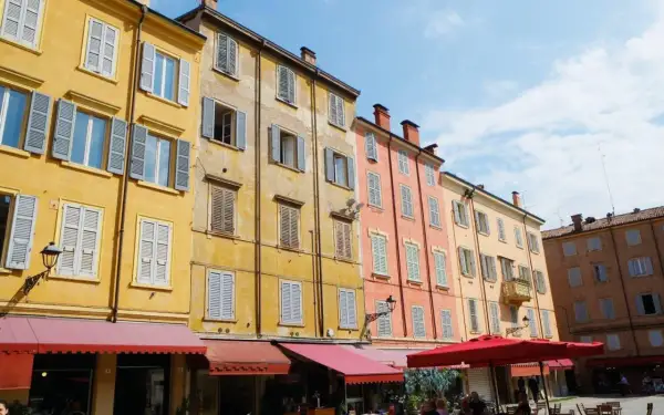 Färgglada hus med persienner i Emilia-Romagna. En solig dag på en italiensk piazza.