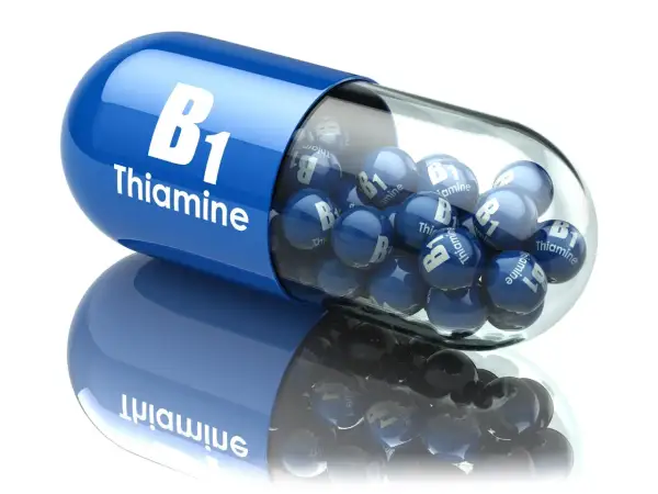 Niebieska kapsułka wypełniona małymi kulkami z napisem "B1 Thiamine". Witamina B1 dla zdrowia.