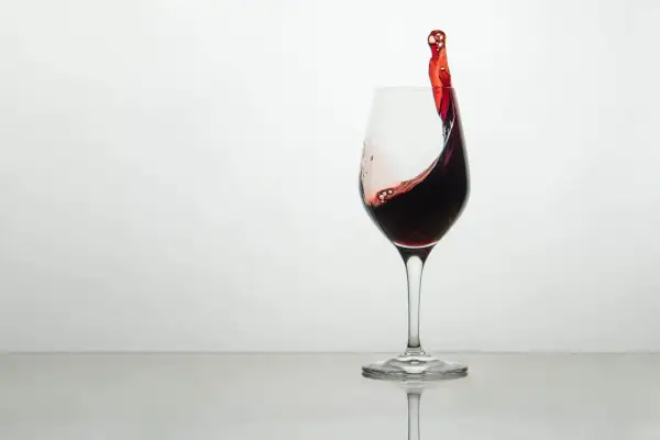 Ein Glas Rotwein mit einer dynamischen Welle, die die Frage aufwirft, wie schmeckt wein.