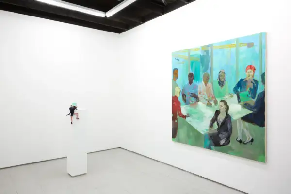 A miniature figure climbs a pedestal in a white-walled gallery, a vibrant painting of a diverse group at a meeting hangs nearby. NYC galleries for emerging artists showcase such intriguing pieces.